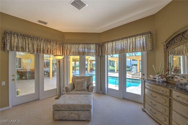 living area featuring light carpet and visible vents