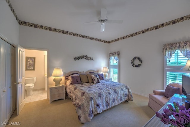 bedroom featuring multiple windows, light colored carpet, and connected bathroom