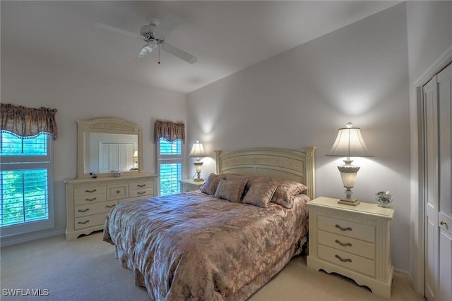 bedroom with light colored carpet, baseboards, and ceiling fan