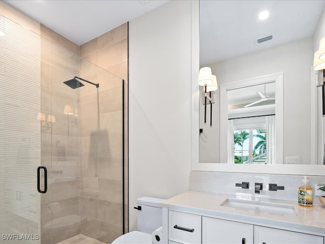 bathroom featuring vanity, an enclosed shower, and toilet