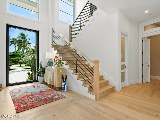 foyer entrance featuring light hardwood / wood-style floors and a high ceiling