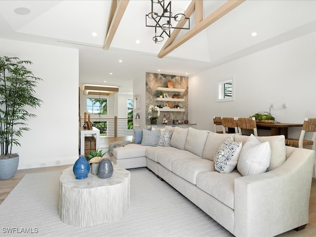 living room with beamed ceiling, plenty of natural light, a chandelier, and light hardwood / wood-style flooring