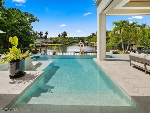 view of swimming pool featuring a patio and a water view