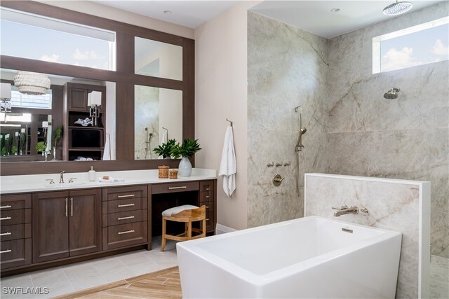 bathroom featuring an inviting chandelier, vanity, and separate shower and tub