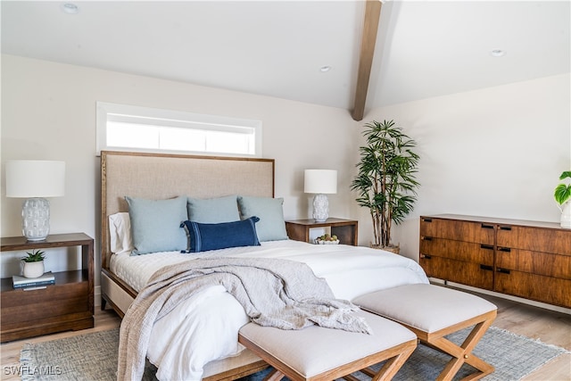 bedroom featuring light hardwood / wood-style flooring and lofted ceiling with beams