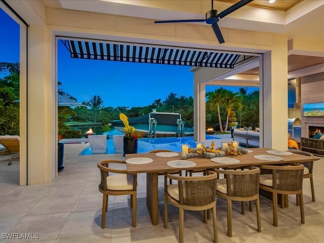 patio terrace at dusk featuring ceiling fan