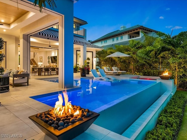 view of swimming pool with a hot tub, a patio area, and a fire pit