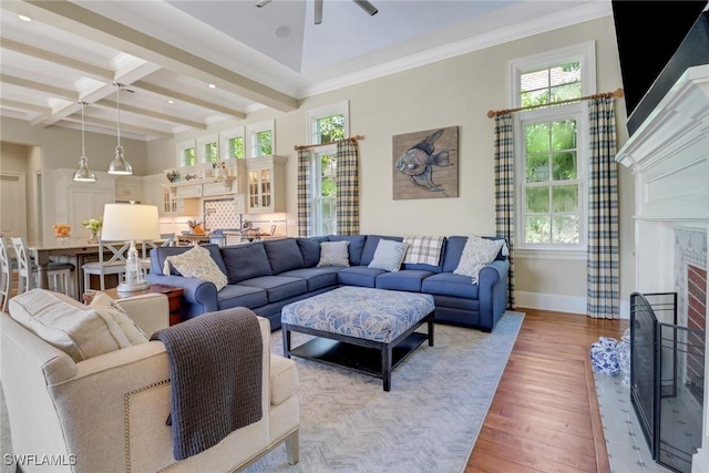 living area featuring light wood-style flooring, baseboards, a ceiling fan, beam ceiling, and coffered ceiling