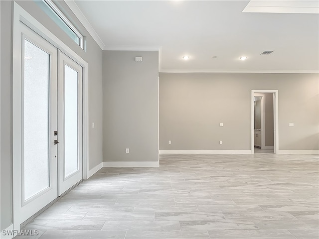 empty room featuring french doors, light hardwood / wood-style flooring, and crown molding