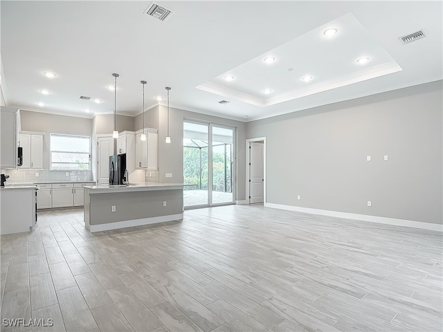 kitchen featuring pendant lighting, white cabinets, light hardwood / wood-style floors, and a kitchen island