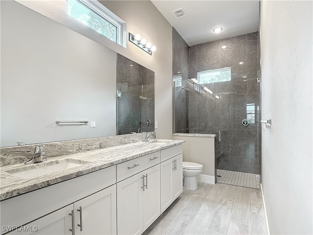 bathroom featuring vanity, a shower with shower door, toilet, and hardwood / wood-style flooring