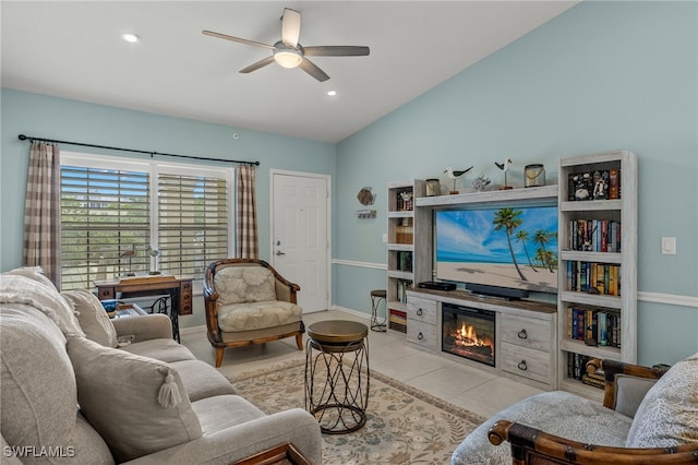 living room with lofted ceiling, ceiling fan, light tile patterned floors, and a fireplace