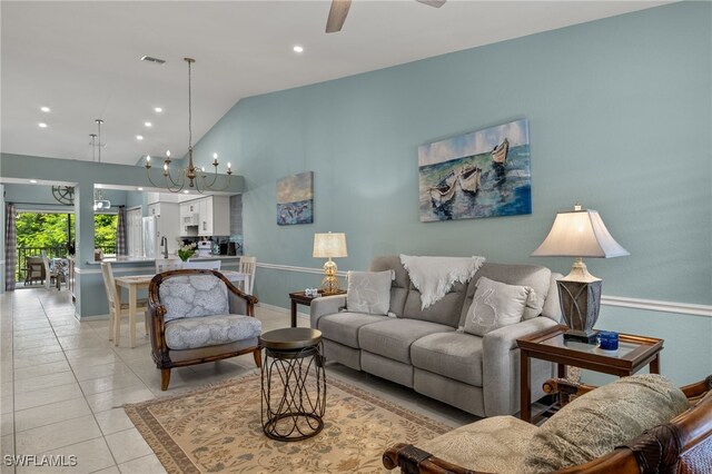 living room featuring light tile patterned floors, vaulted ceiling, and ceiling fan with notable chandelier