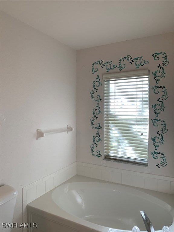 bathroom with a tub and toilet