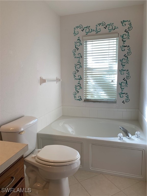 bathroom featuring tile patterned flooring, a tub to relax in, toilet, and vanity