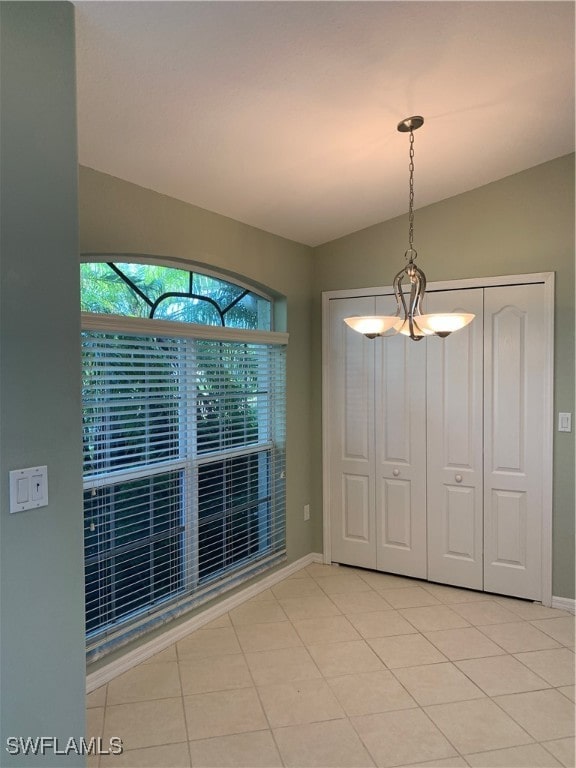 unfurnished dining area featuring an inviting chandelier and light tile patterned flooring