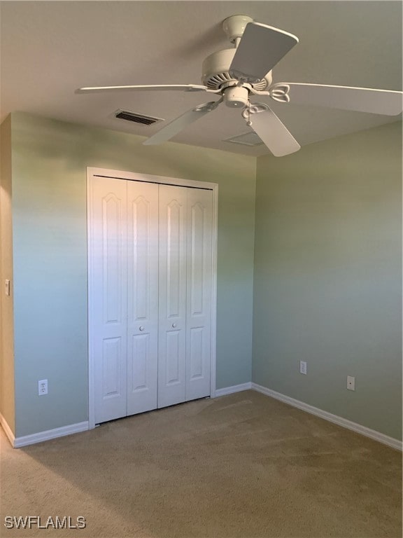 unfurnished bedroom with a closet, ceiling fan, and carpet floors