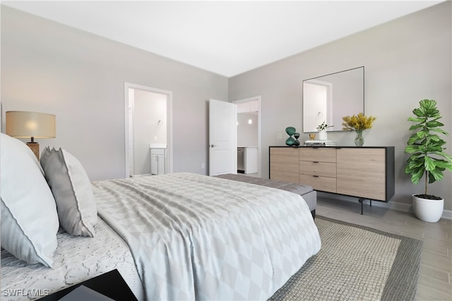 bedroom with light wood-type flooring and connected bathroom