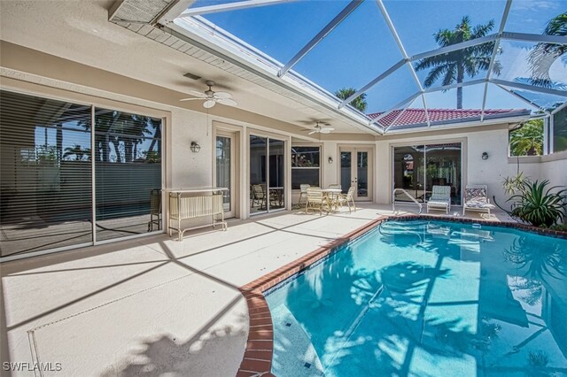 view of swimming pool featuring ceiling fan, a lanai, and a patio