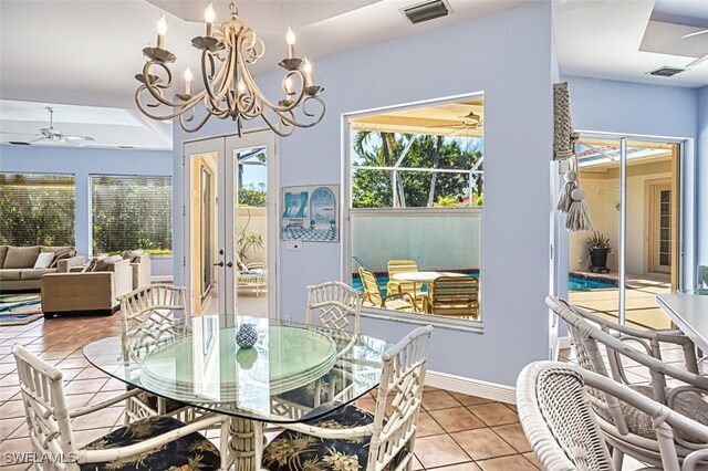 tiled dining room featuring ceiling fan with notable chandelier