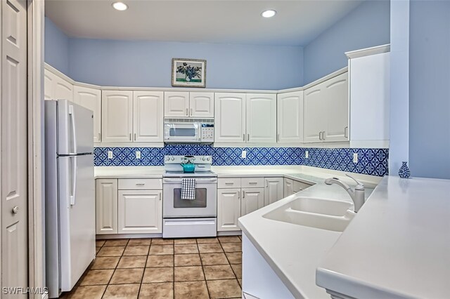 kitchen with white cabinetry, white appliances, backsplash, sink, and light tile patterned flooring