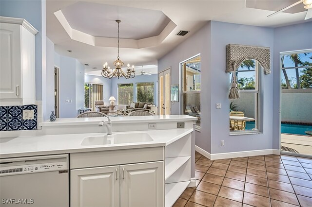 kitchen featuring dishwasher, pendant lighting, ceiling fan with notable chandelier, and white cabinetry