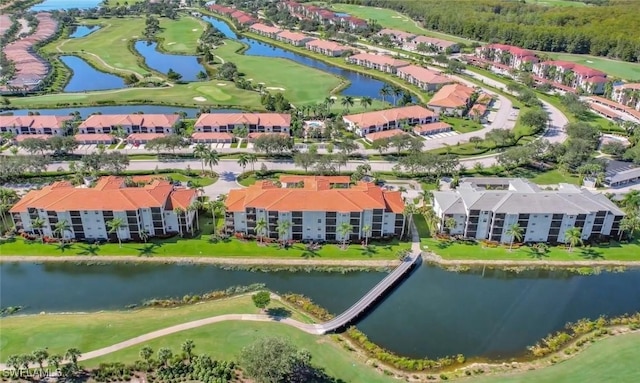 drone / aerial view with view of golf course and a water view