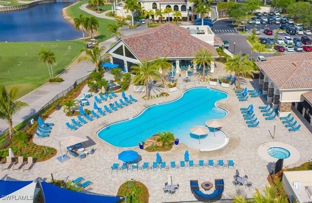 view of pool featuring a water view and a patio