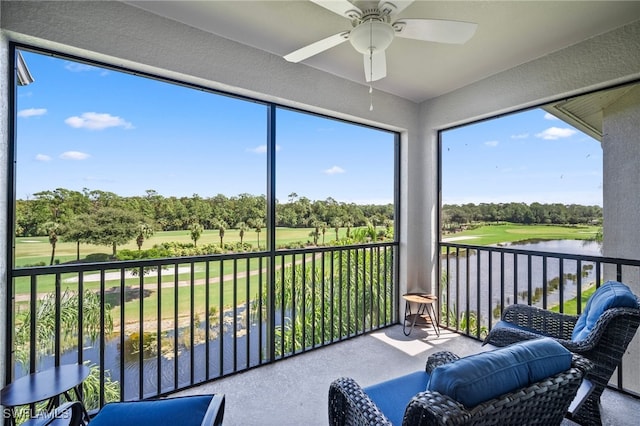 sunroom / solarium with a water view and ceiling fan