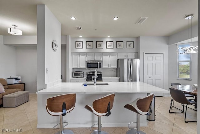 kitchen with kitchen peninsula, a breakfast bar, stainless steel appliances, and decorative light fixtures