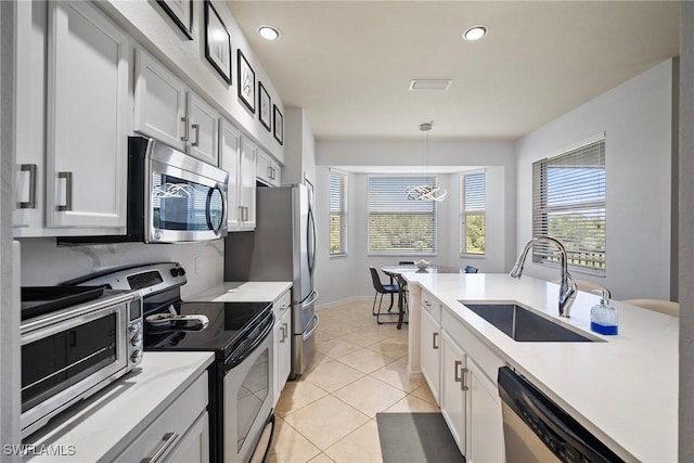 kitchen featuring light tile patterned flooring, stainless steel appliances, pendant lighting, a sink, and recessed lighting