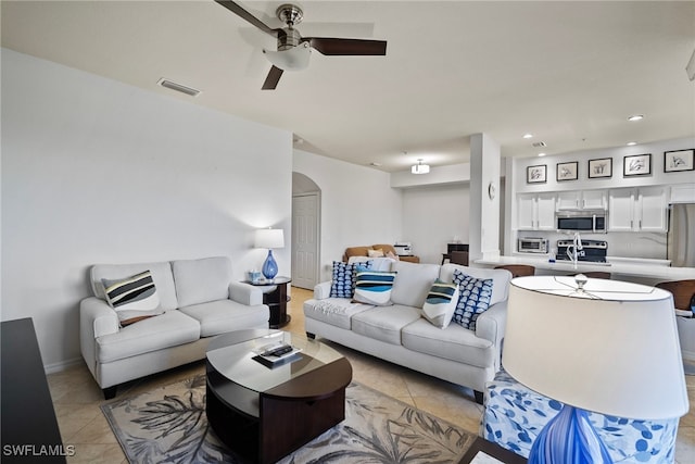 living room featuring sink, light tile patterned flooring, and ceiling fan