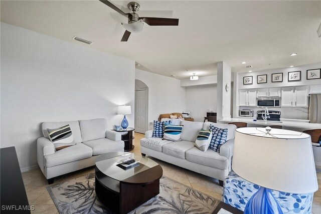 living area with arched walkways, ceiling fan, light tile patterned floors, recessed lighting, and visible vents