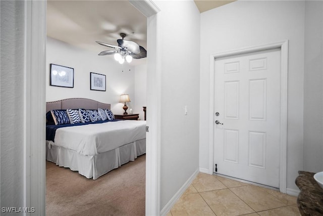 bedroom with light tile patterned floors, baseboards, a ceiling fan, and light colored carpet