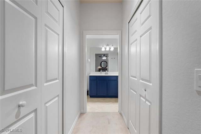 corridor featuring sink and light colored carpet