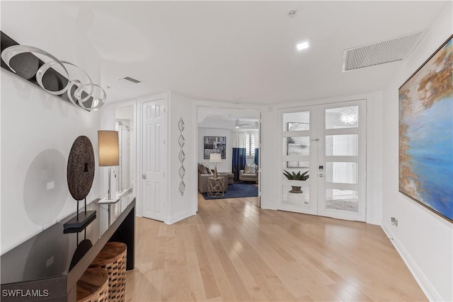 entrance foyer featuring ceiling fan, french doors, and light wood-type flooring