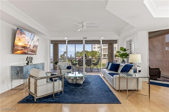 living room featuring ceiling fan, light wood-type flooring, and ornamental molding