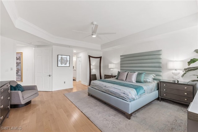 bedroom featuring a raised ceiling, ceiling fan, light hardwood / wood-style flooring, and crown molding