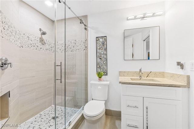 bathroom with an enclosed shower, vanity, and toilet