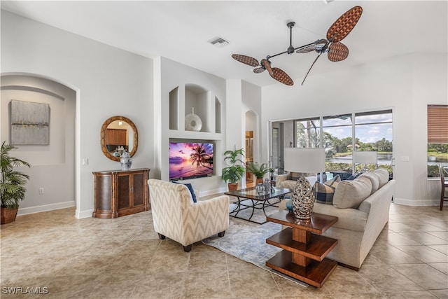 living room with light tile patterned floors, vaulted ceiling, ceiling fan, and built in features