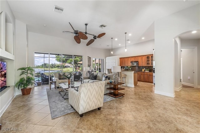 tiled living room with a high ceiling and ceiling fan