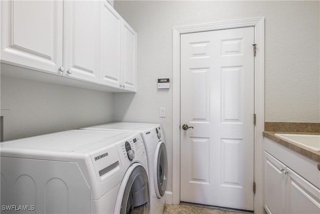 washroom featuring cabinets, washer and dryer, and sink