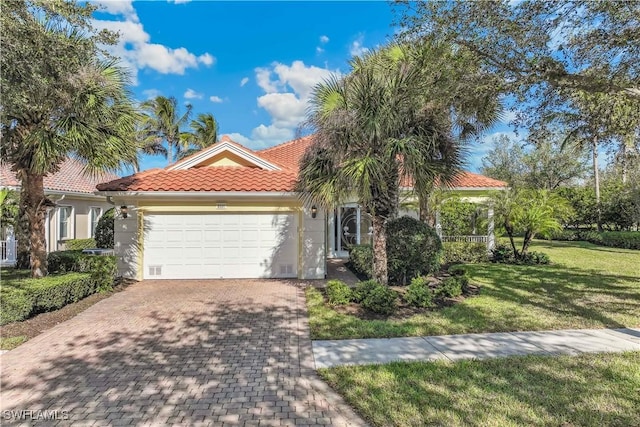 mediterranean / spanish-style house featuring a front lawn and a garage