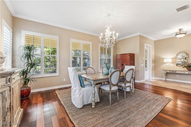 dining area with crown molding, dark wood-type flooring, and a chandelier