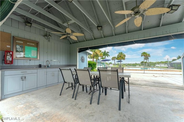 view of patio / terrace featuring a sink, fence, outdoor dining area, and a ceiling fan