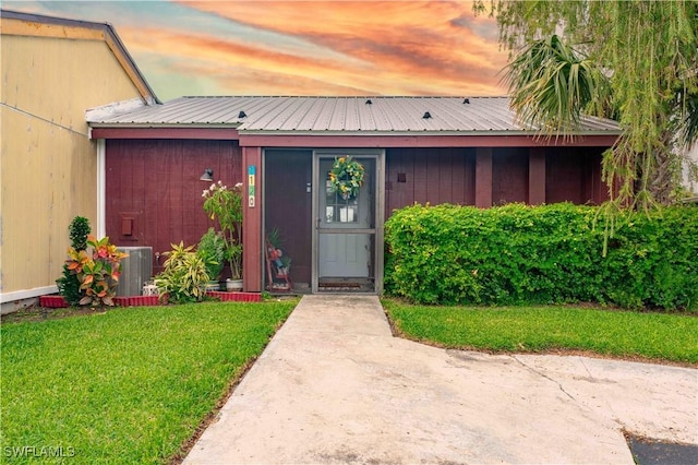 property entrance featuring metal roof and a yard