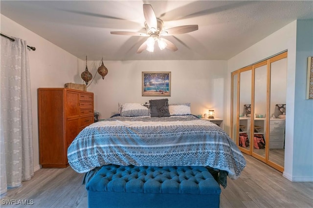 bedroom with ceiling fan, light wood finished floors, and a closet