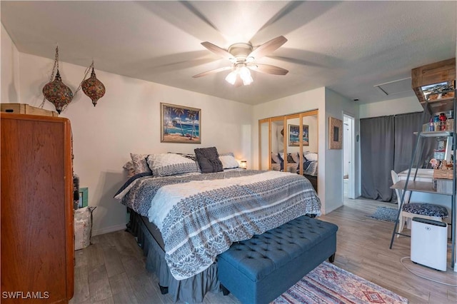 bedroom with baseboards, a closet, a ceiling fan, and wood finished floors