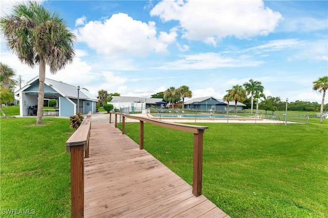 exterior space with a yard, a community pool, and fence