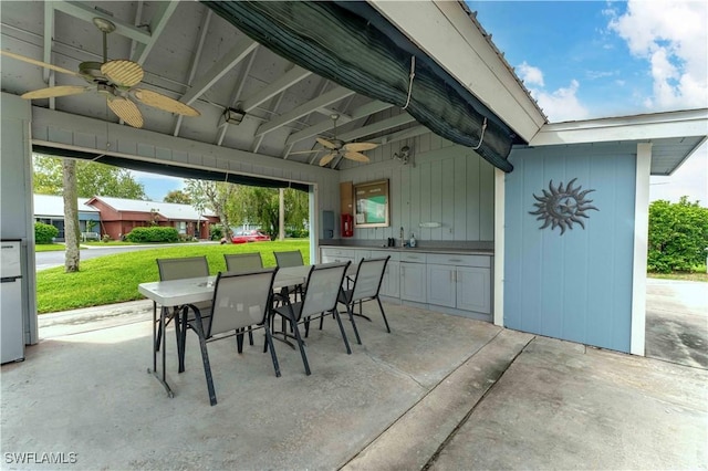 view of patio / terrace featuring exterior kitchen, outdoor dining area, and a ceiling fan